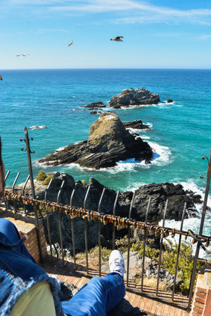 Man contemplating the views of some rocks in the mediterranean a sunny day