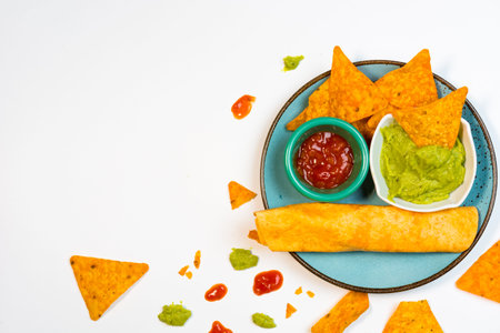 Nachos with guacamole on a white background. Typical aperitif of Mexican food.