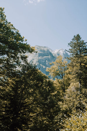 A woman hiking in the Aran valley in Spain, exactly in Artiga de Lin, where there are waterfalls and...