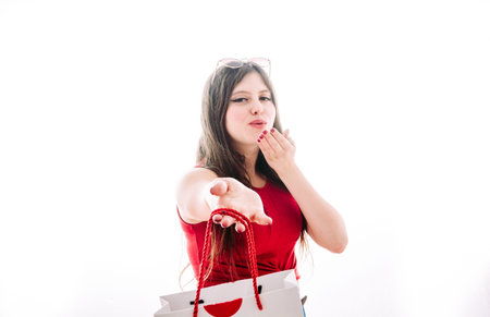 Girl giving you a bag with gifts to celebrate valentine's day.の写真素材