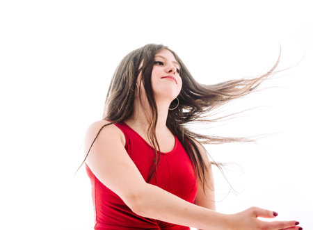 17-year-old teenage girl moving her hair freely over white background