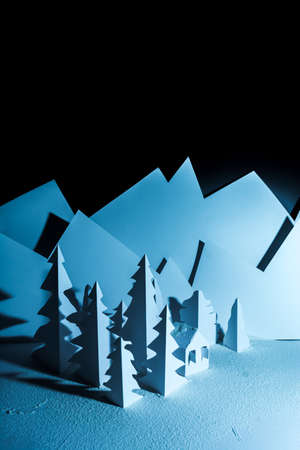 Snowy landscape of high mountain with white pines, and house in the middle of the landscape. Composition made in paperの写真素材