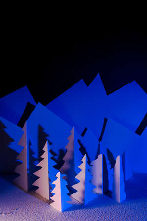 Snowy landscape of high mountain with white pines, and house in the middle of the landscape. Composition made in paperの写真素材