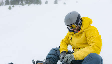 Free rider with snowshoes and snowboard on his back, contemplating the snowy landscape around himの写真素材