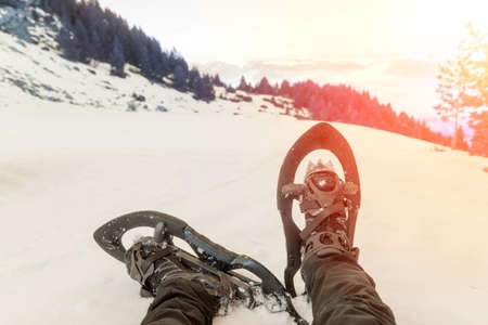 Snowshoes resting sitting while contemplating the sunset on a snowy dayの写真素材
