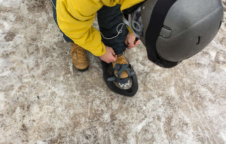 A sporty man putting on his snowshoes to start a snowy mountain excursion. He loves winter sportsの写真素材