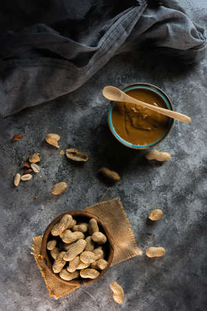 Aerial view photograph of homemade peanut butter in a blue bowl and one hand preparing itの写真素材