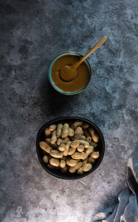 Aerial view photograph of homemade peanut butter in a blue bowl and one hand preparing itの写真素材