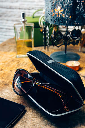 Desk full of outfit for women like sunglasses, earrings, mobile phoneの写真素材