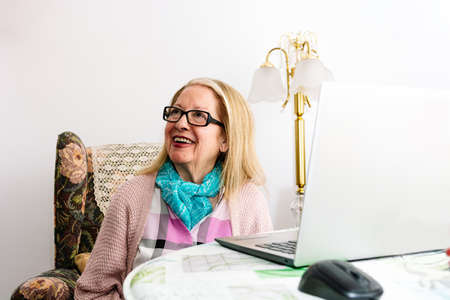78-year-old grandmother using a laptop at home (concept of technologies for the elderly)の写真素材