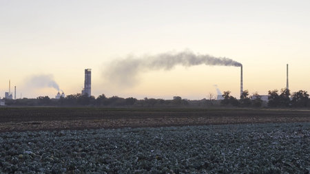 Heavy gray smoke is poured from the chimney pipes of thermal power plant. Carbon dioxide emitting from chimneys from industrial factory into the atmosphere. Concept of environmental pollution problemの写真素材