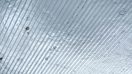 Heavy rain drumming on the transparent plexiglass roof. Beautiful rainy scene on summer day. Concept of tranquility nature scene. Close up Slow motionの写真素材