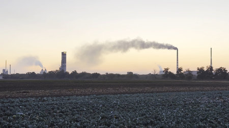 Heavy gray smoke is poured from the chimney pipes of thermal power plant. Carbon dioxide emitting from chimneys from industrial factory into the atmosphere. Concept of environmental pollution problemの写真素材