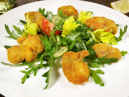 Breaded Veal Appetizer on green Rucola Lettuce and Vegetables isolated on white backgroundの写真素材