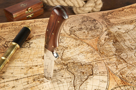 Knife sticking in an old map to locate the treasureの写真素材