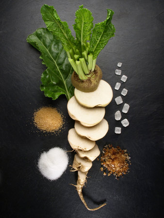 Sugar Beet with Leaves and various Sugar on black Background