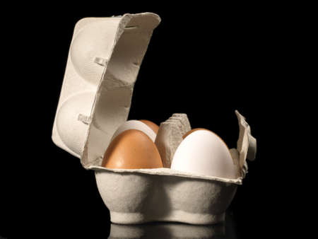 Eggs in a box on black backgroundの写真素材