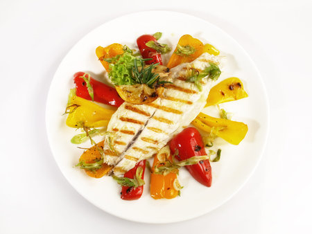 Grilled Fish Fillet with roasted Peppers and Vegetables - Low Carb Sea Food Plate isolated on white...