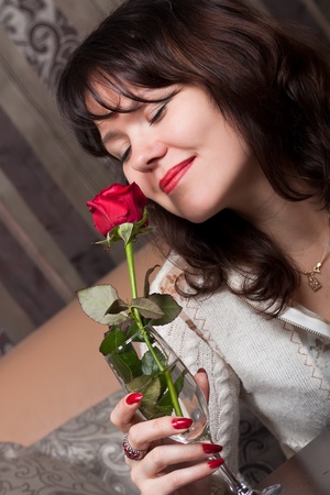 Young cute lady with a red roseの写真素材