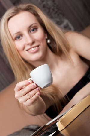 Smiling young girl with a cup of coffeeの写真素材