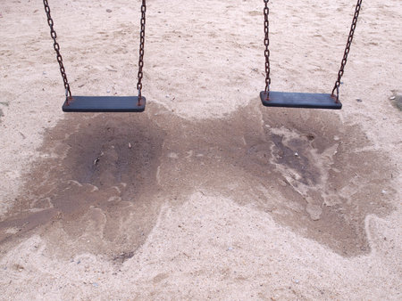 Swing in playground hanging over sand surface