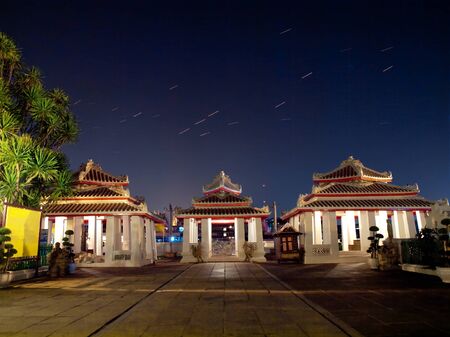 Chinese style pavilion in Wat Arun(Temple of Dawn) with star trails above the Bangkok city, Bangkok, Thailandの写真素材