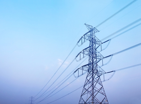 High voltage post against clear blue skyの写真素材