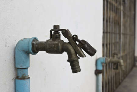 Old faucets locked by master keyの写真素材