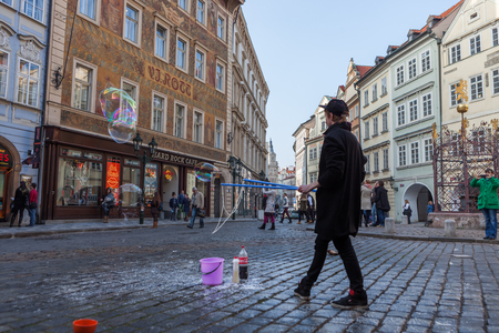 PRAGUE, CZECH REPUBLIC - MARCH 8th, 2014 - Boy makes extra big bubbles in city centerのeditorial素材