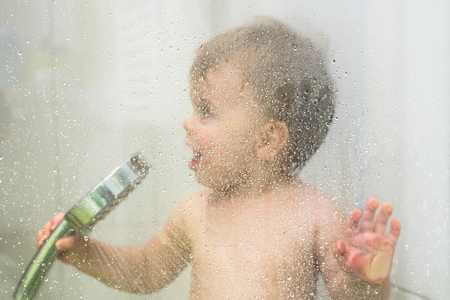 Young baby toddler boy in showerの写真素材