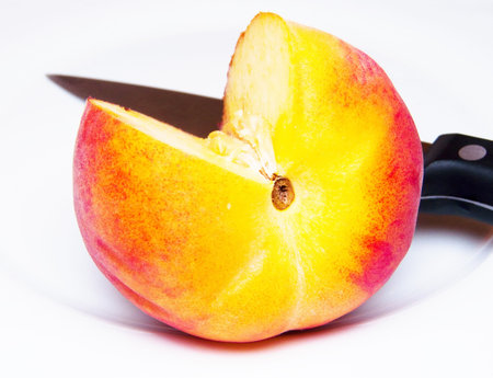 ripe peach knifed isolated whiteの写真素材
