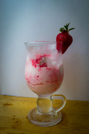 Strawberry ice cream with blurried strawberry and Milk on a foregroundの写真素材