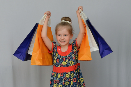 The little girl, the buyer holds the colored shopping bags.の写真素材