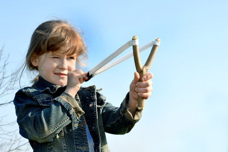 Kid, child shoots a slingshot. Conceptual photography.の写真素材