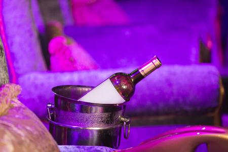 Wine bottle in a bucket with ice on the couch. Black and white photo.の写真素材
