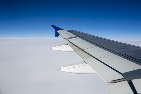Plane flying over the clouds. Plane take off. View from the window. Jet plane take off at dusk. SUN ascending from behind the horizon.の写真素材