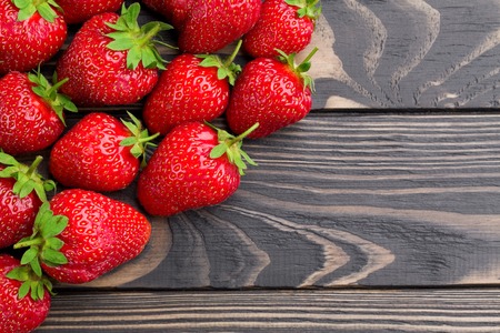 Ripe juicy sweet strawberries over styled old aged wooden turquoise table close-up. Vintage background with free copy text space.の写真素材