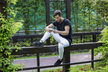 attractive young male model playing games on a smart-phone.の写真素材