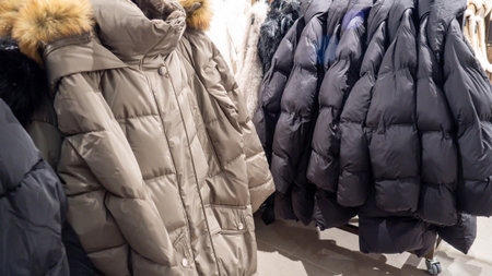 Metal Rack Presenting Gray And Navy Padded Jackets Featuring Quilted Stitching