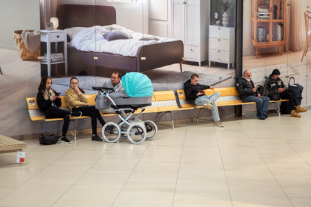 People relax on benches in a spacious furniture store. Brno March 21, 2026