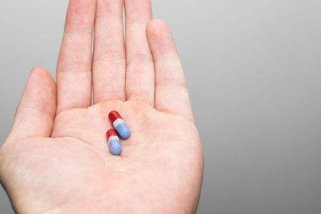 Red and blue pills in men hand