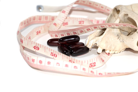 pill , skull and Tape Measure on White Background in Waistline and Weight Control Concept.on white...