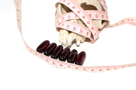 pill , skull and Tape Measure on White Background in Waistline and Weight Control Concept.on white background isolate. fat loss pill can kill you.の写真素材