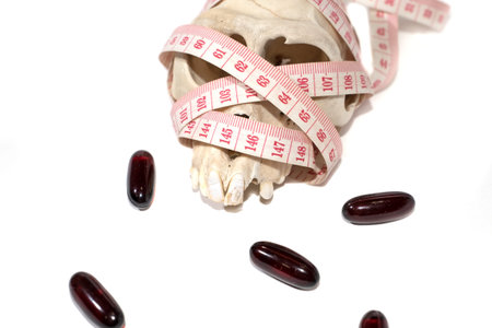 pill , skull and Tape Measure on White Background in Waistline and Weight Control Concept.on white background isolate. fat loss pill can kill you.の写真素材