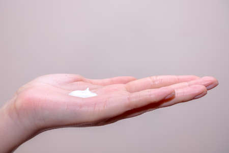 Beautiful young woman hands with creamの写真素材