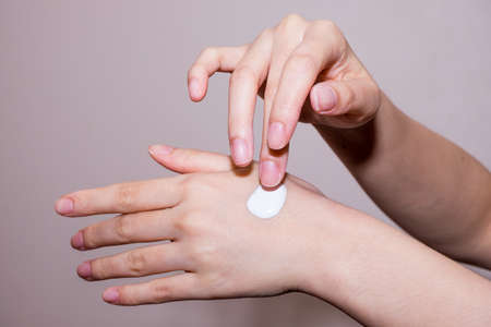Woman applying moisturizing cream on handsの写真素材
