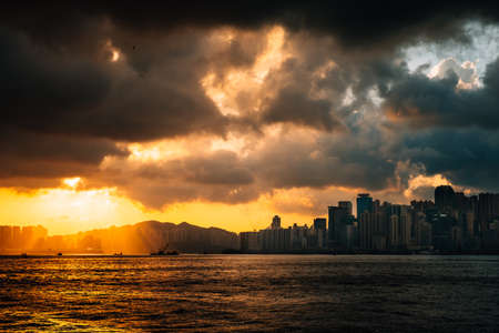Hong Kong sunset at harbour with sunlight beamの写真素材