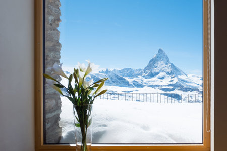 Scenic view on snowy Matterhorn peak in sunny day with blue sky and blur window in foreground, Switzerland.の写真素材