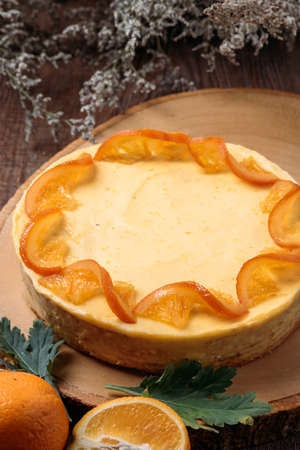 Orange pound cake with fresh orange slices on top , on wood tableの写真素材