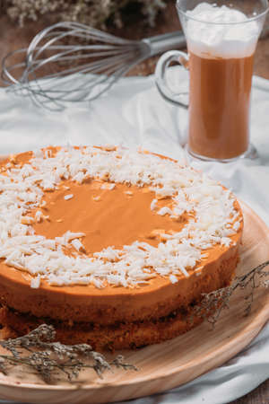 Thai tea cake with white chocolate on top , thai tea glass on tabbleの写真素材